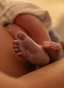 Foto de um bebê recém nascido nas mãos de uma enfermeira